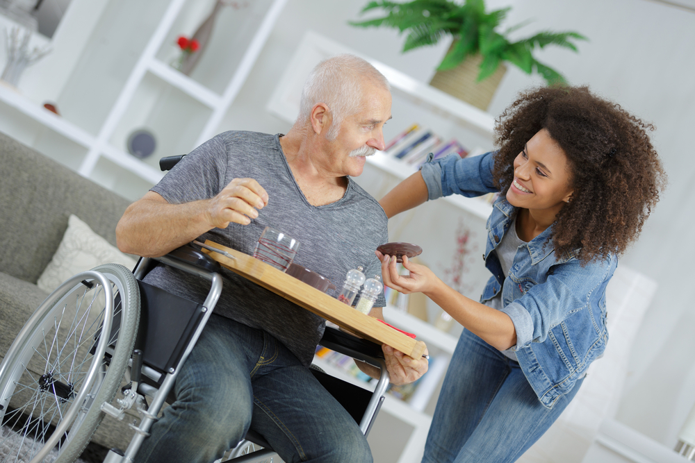 Senior with Alzheimer’s disease being fed in a wheelchair.