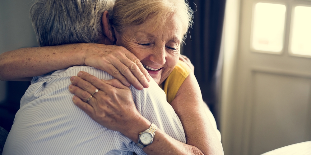 Two seniors hugging.