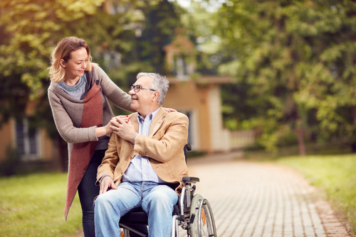 A woman and an elderly man shopwcasing patient-centered care in the park.