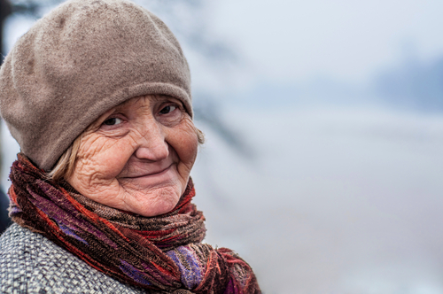 Elderly woman out in the cold during winter.