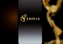 Emmys logo displayed on a smartphone screen with a blurred gold award statuette in the background^ television industry awards and digital streaming concept. Kaunas^ Lithuania - 2026 March 24