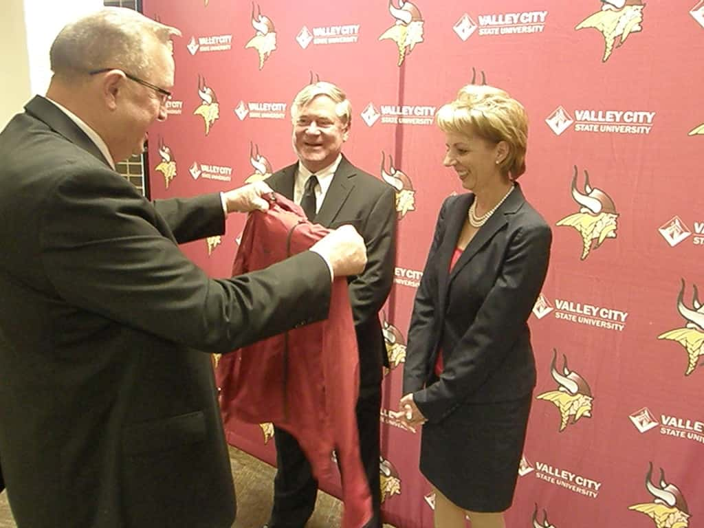 VCSU Executive Director of University Advancement Larry Robinson presents the president Mason with her first VCSU jacket with her husband Bill Mason at her side. Photos by Steve Urness.