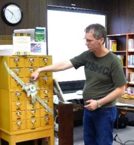 Marty Olson, Historian for the Jamestown Community Gardens, cuts the ribbon for the new Seed Catalog at Stutsman County Library. Photo courtesy of JRVLS.