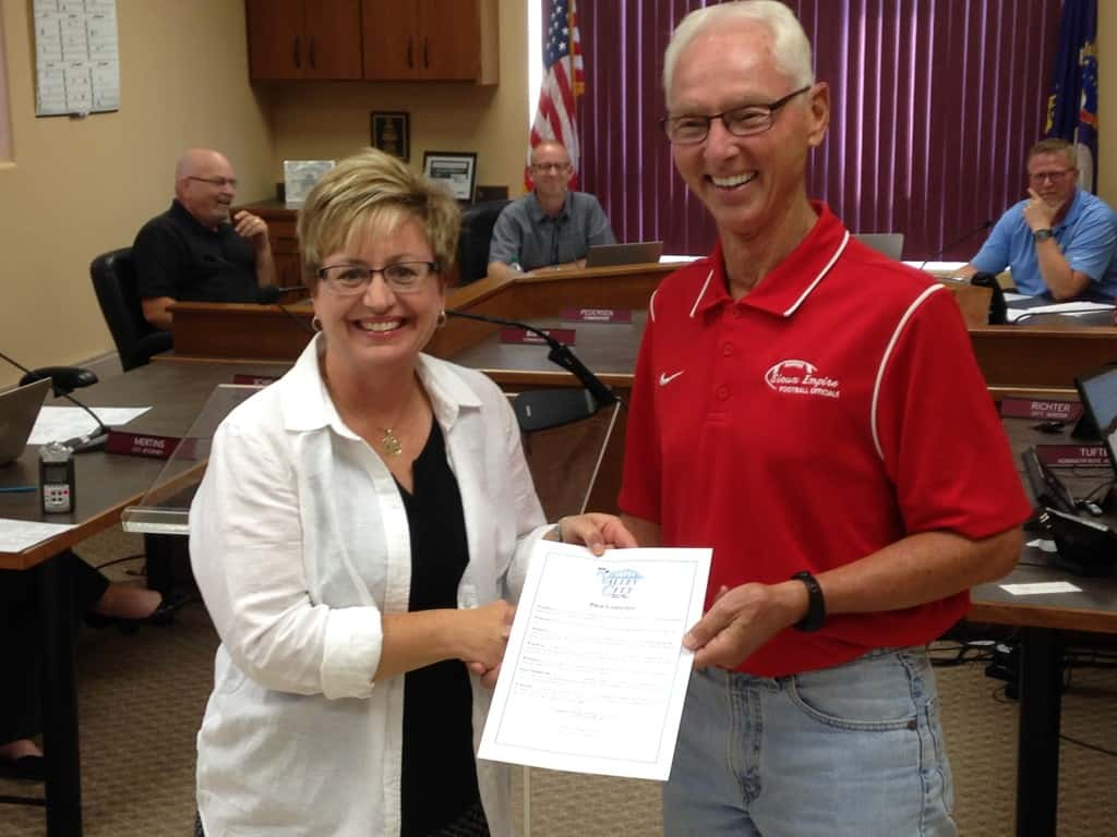 R to L Valley City Mayor Dave Carlsrud hands the proclamation to Andrea Winter of ON THE MOVE during the August 1st city commission meeting. Photo by Steve Urness.