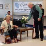 Peggy Kvien receives a white rose from her husband Mickey as his wife was recognized for her years of service by several staff members during the social.