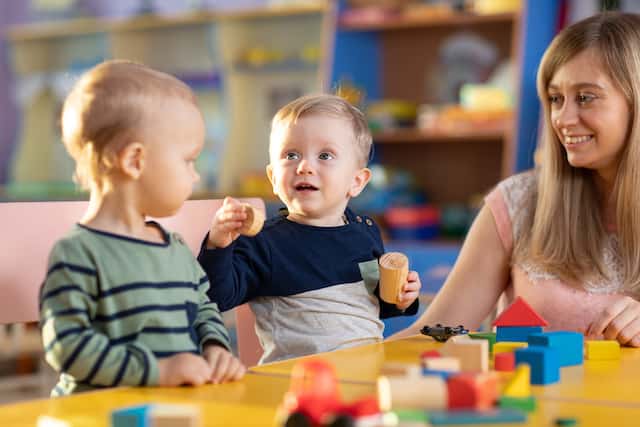 babies-playing-with-teacher-in-kindergarten-or-nursery