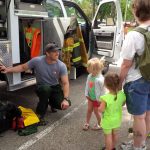 Image-2: North Dakota Forest Service fire staff teaches a family about wildland fire by showing them wildland firefighting equipment.
