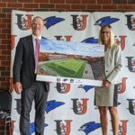 IMG_20200721_122756: L to R: Dr. Rob Lech and Dr. Polly Peterson hold a rendering of the proposed shared use facility.