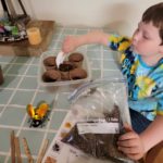 Kyler Howe: A student at St. Catherine School, fills containers with soil as he prepares to plant his seeds.