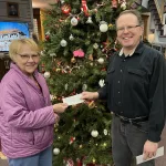 Museum donation: Carol Faulkner hands Wes Anderson a $100 check donation for the museum from the Eagles Club Auxiliary.