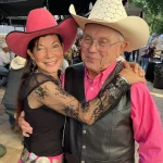 Medora: Goldie Ann Taylor (Buck Taylor's) wife gives a hug to board member Dick Nelson of Valley City.