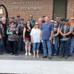 Red Knights Check Ceremony: Front and center, Anita and Kevin Tulp accepts a $500 check from the Red Knights after they lost their home to fire back in August of 2024 in Valley City.