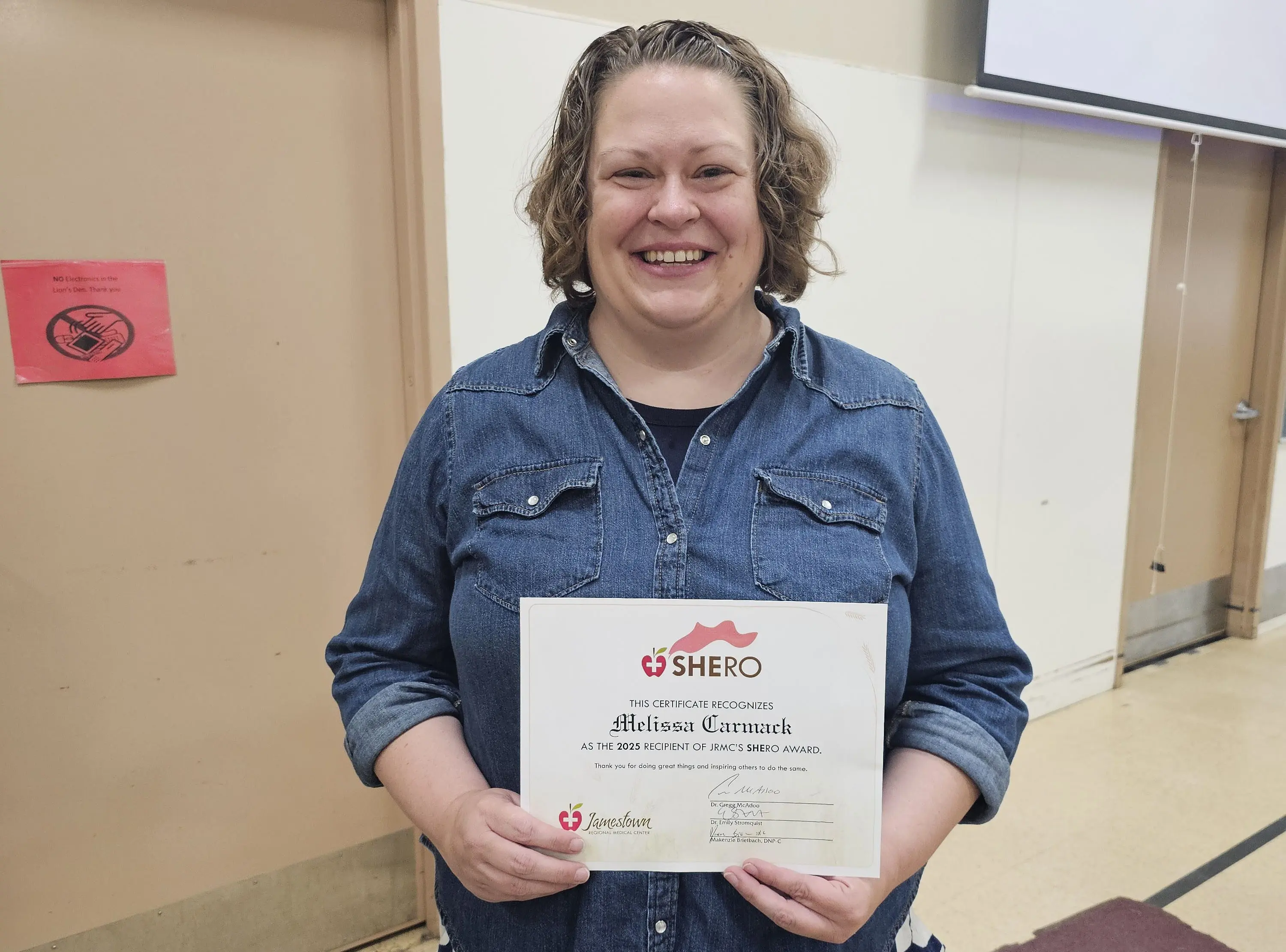Melissa Carmack proudly holds her SHERO Award certificate after being named JRMC’s 2025 recipient at Lincoln Elementary’s end of school assembly.