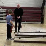 Fr. Paul Duchschere: Provides a few putting tips at the mini golf station.