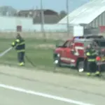 firefighter puts out grass fire.