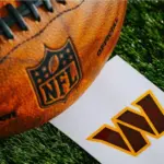 Washington Commanders NFL team Logo and American football ball on Green Grass.