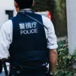 Japanese police squad formation in protective uniform with "Police" logo^ policemen patrol maintain public during political demonstration protest rally in the streets of Tokyo city center^ Japan