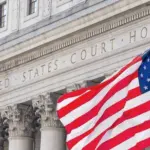 American flag waving in the wind in front of United States Court House in New York