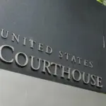 The United States Courthouse sign stands tall amidst a serene backdrop of trees at the US District Court in Seattle^ Washington. Seattle - May 17^ 2019: