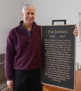 Alan Robinson standing with Eva Leonard's plaque