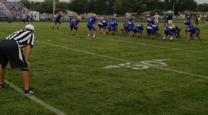 Raccoon Valley Bank president and official Terry Nielsen overlooks Ryan Rathje operating the Perry JV offense against the first team defense.