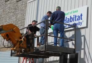 Harry Ahrenholtz (left), Jeff Lamoureux (middle) and Gary Von Ahsen (right) install sign