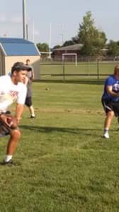 Iowa State Linebacker Kane Seeley works with youth football players.