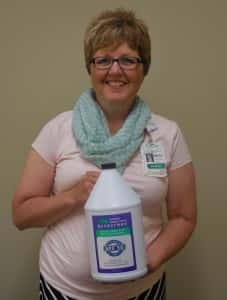 Public Health Director Becky Wolf holds one of the jugs of free sunscreen