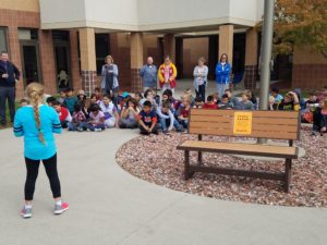 The new "Buddy Bench" at Perry Elementary, and a 4th-grade student reading the rules for it
