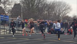 ADM track athletes Josi Lonneman (blond hair) and Keaton Kester (brown hair) run side by side during the 100 meter dash at the Earlham Early Bird Invitational Tuesday. Photo by RVR's Nate Gonner.