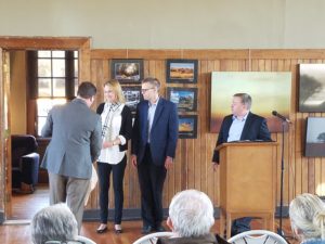 Matt McDevitt (left) and John McGee (right) present a gift to Jay and Denise Hartz