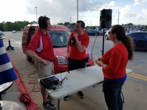 Raccoon Valley Radio's Shawn Kenney (left) broadcasts live on air from the Hy-Vee All-American Cookout with Store Manager Matt Rohe (center) and Chamber Director Lynsi Pasutti (right)