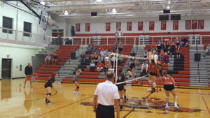 ADM senior Sami Schepers (Black No. 5) smashes a kill against two Boone defenders in ADM's regional opener on October 18 2017. Photo by RVR's Nate Gonner.
