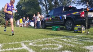 West Central Valley junior Louden Foster grabs for his race number ahead of crossing the finish line at the Wildcat Cross Country Classic on August 30 in Menlo. Photo by RVR's Nate Gonner. 