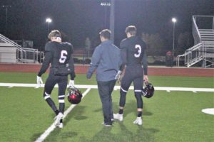 ADM seniors Andrew Flora (No. 6) and Nolan Harsh (No. 3) walk off the field on either side of head coach Garrison Carter after ADM's 42-21 victory over Winterset on October 12. Photo courtesy of Susan Harshman/ADM Tiger Football. 