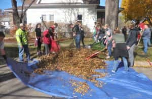 High School students help rake leafs onto tarp, which were crushed with City of Jefferson garbage trucks