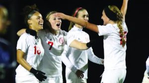 ADM grad Sydney Bertman (No. 7) celebrates with her teammates after scoring the go-ahead goal against the Peru State Bobcats on October 6. Photo courtesy of Grand View University Athletics. 
