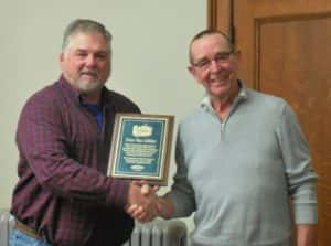 Greene County Supervisor Chair John Muir (left) handing retiring Assistant to the County Engineer Don Van Gilder (right) his plaque for his 44 years of service