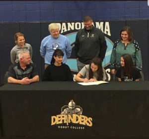 Panorama senior Bailey Beckman (center gray shirt) signs a letter of intent to play basketball and run track at Dordt College. Photo courtesy of PHS Girls Basketball Twitter Account.