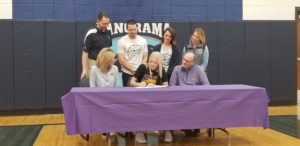 Panorama senior Morgan Johnk (center) puts pen to paper, signing a letter of intent to compete next year for the University of Northern Iowa Womens Track and Field Program. Photo by RVR's Nate Gonner. 