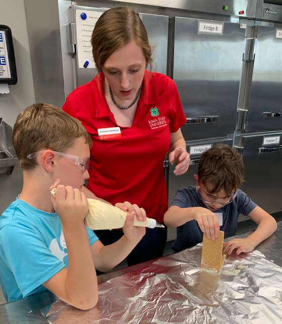 sam-with-two-students-welding-with-graham-crackers-and-frosting