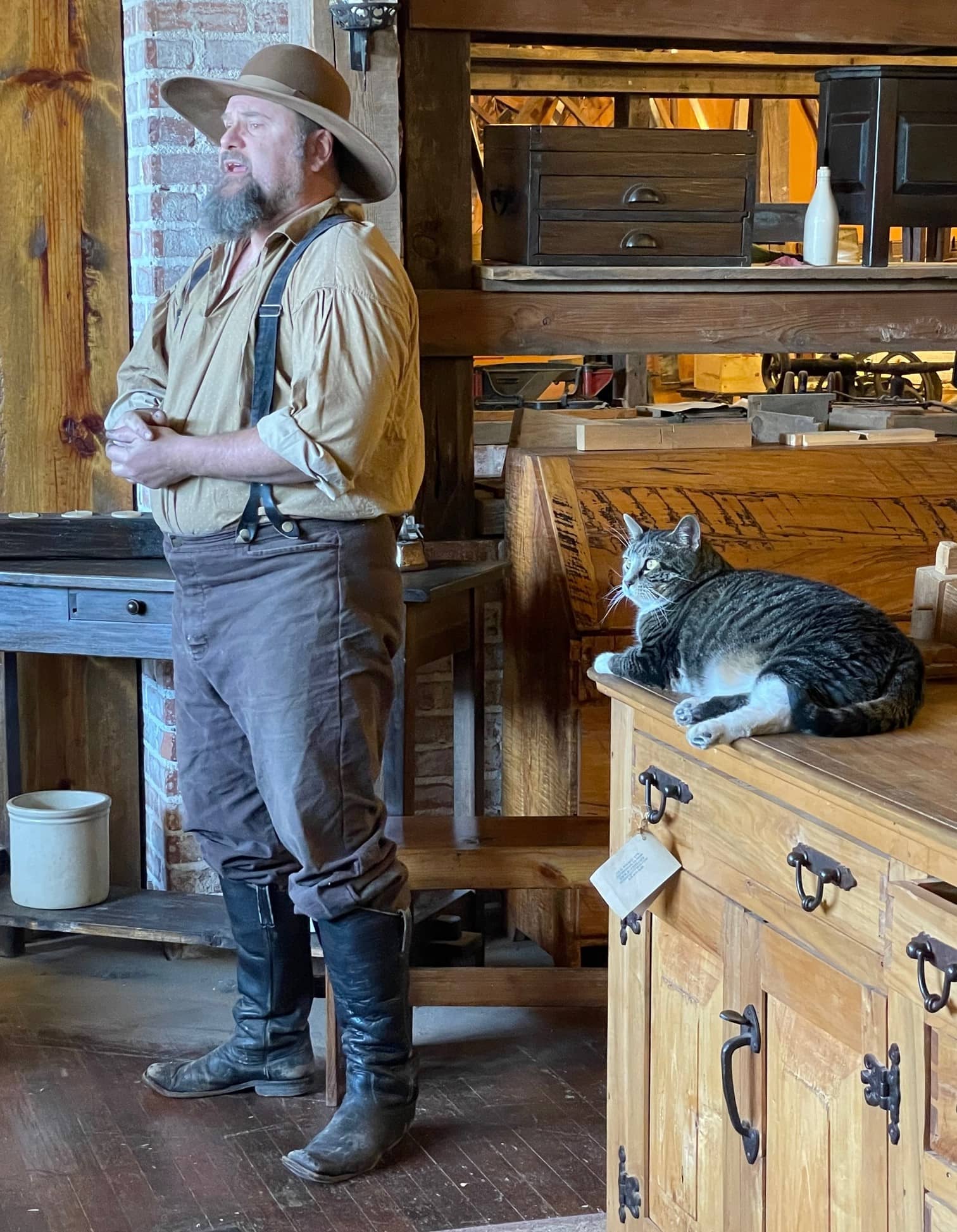 robby-pedersen-and-his-cat-hound-talking-to-visitors-at-his-rvp-1875-shop