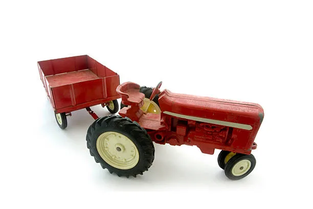 antique-red-international-toy-tractor-with-wagon-on-white-background