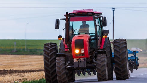 agricultural-tractor-moving-on-the-asphalt-road-after-working-in-field