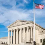 Facade of the United States Suprement Court with American flag in Washington^ DC
