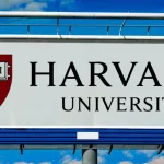 billboard displaying logo of Harvard University^ a private Ivy League research university in Cambridge^ Massachusettsl