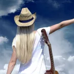 Young woman with guitar on the road and her vintage baggage