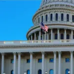 Close-up of the United States flag in front of the Capitol Building's dome in the morning^ Washington^ D.C.