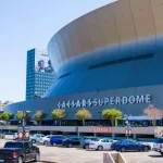 NEW ORLEANS^ LA^ USA - APRIL 3^ 2022: Superdome with parking lot and hint of the skyline during NCAA Men's Final Four Basketball Tournament