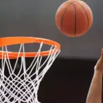Orange basketball ball flying into the basketball hoop